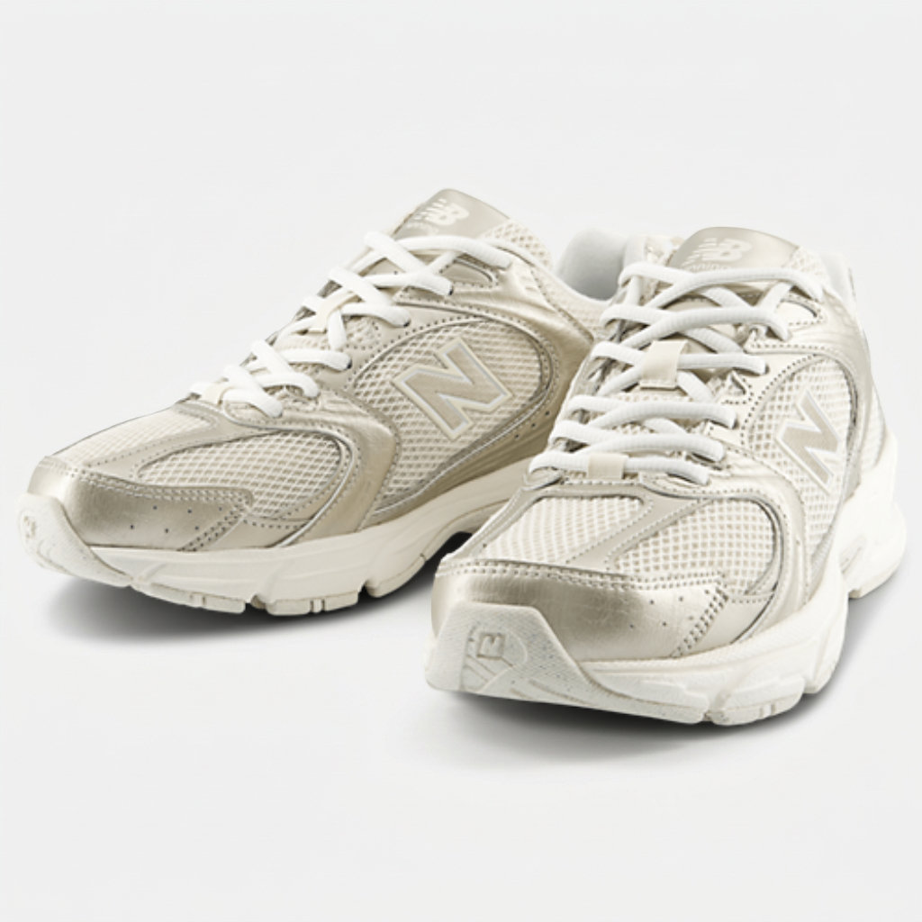 New Balance 530 Gold Metallic Linen — vista frontal New Balance 530 Gold Metallic Linen em perspetiva 3/4, com sobreposições metalizadas douradas