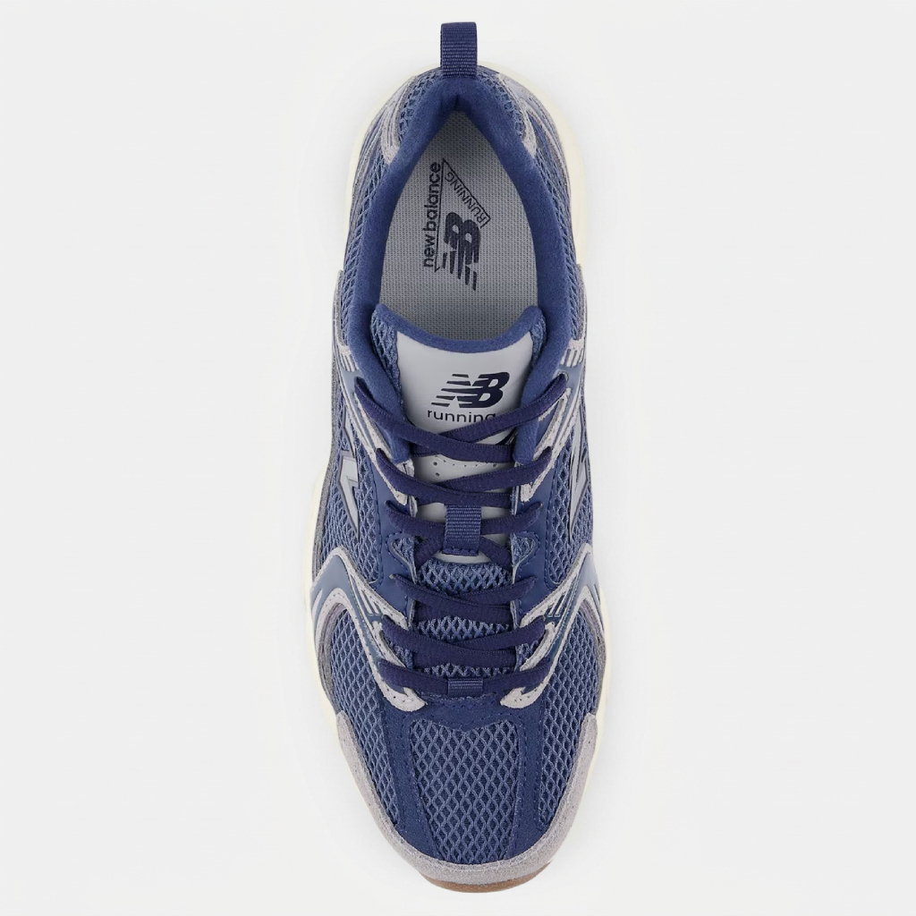 New Balance 530 Navy Vintage vista superior Vista lateral das New Balance 530 Navy Vintage, destacando a silhueta retro, os detalhes em azul-marinho e a estética clássica do modelo.