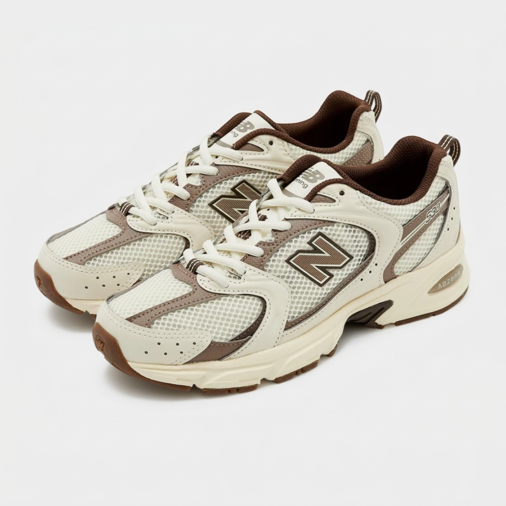 New Balance 530 Turtledove — vista 3/4 Par de New Balance 530 Turtledove em perspetiva 3/4 com atacadores brancos