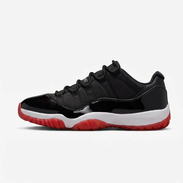 Air Jordan 11 Low Bred 2025 preto e vermelho, vista lateral com guarda-lama envernizado